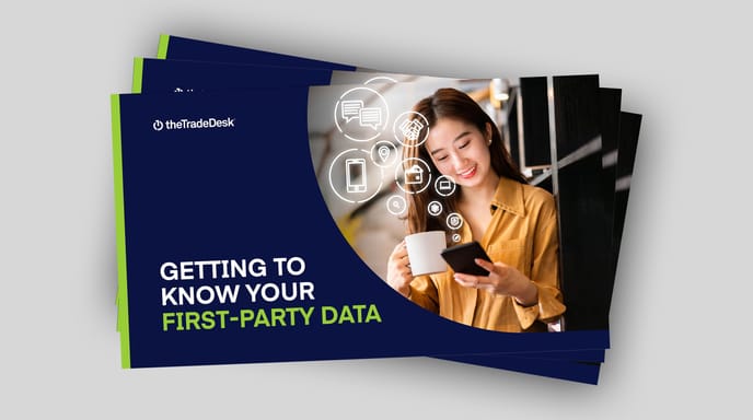 A woman smiles at her phone on a booklet titled “Getting to Know Your First-Party Data.”