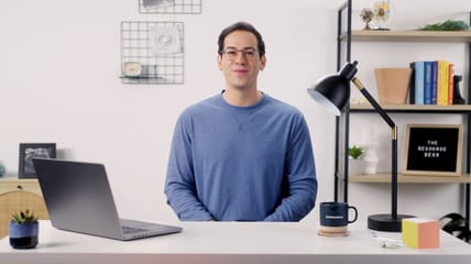 Person sitting at a modern desk with laptop and office decor, ready for a video session