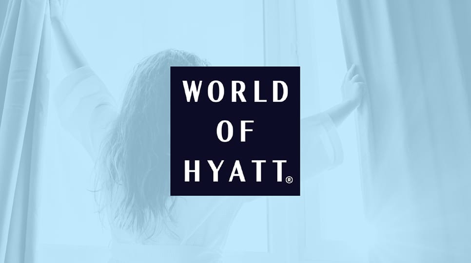 Woman wearing a white robe and opening window curtains to let the sun in with a blue overlay and the World of Hyatt logo in the center