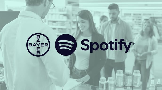 Group of people making purchases in a pharmacy with a green shade over and Bayer and Spotify logos in the center