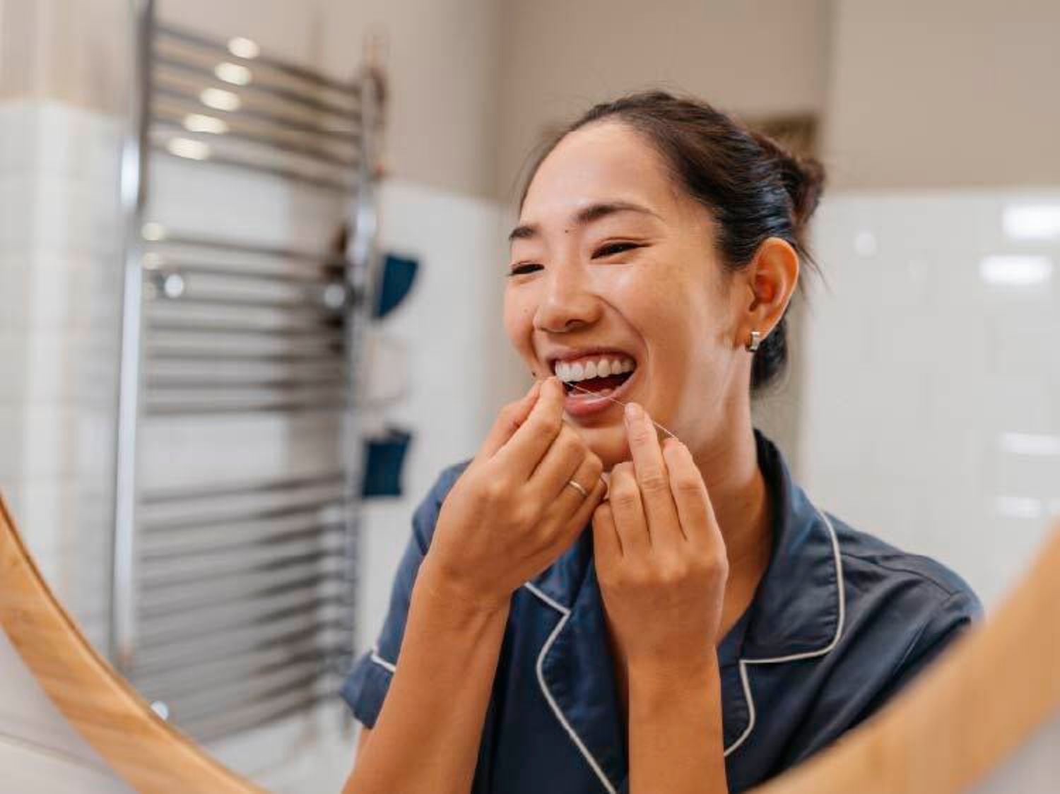 Woman flossing her teeth while in her bathroom
