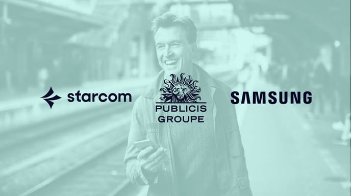A smiling man holding a smartphone stands on a train platform, overlaid with the logos of Starcom, Publicis Groupe, and Samsung.