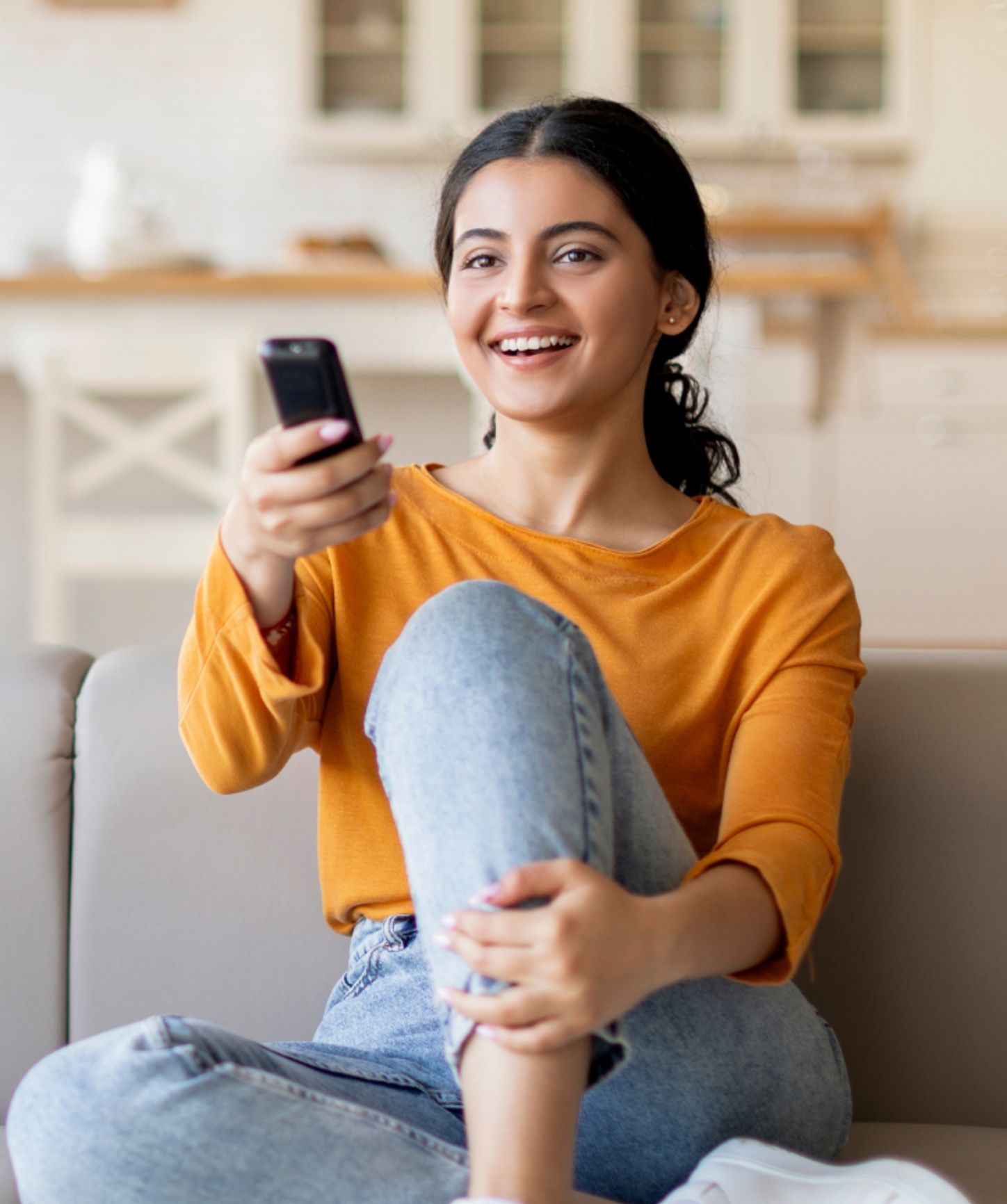 Woman watching TV and using her remote