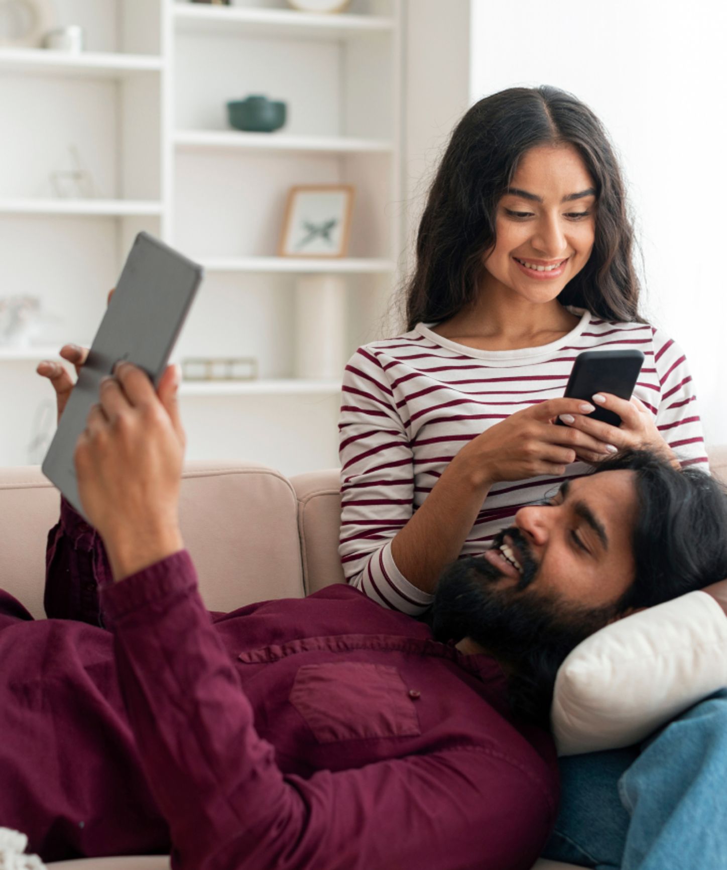 A couple relaxing and looking at their devices