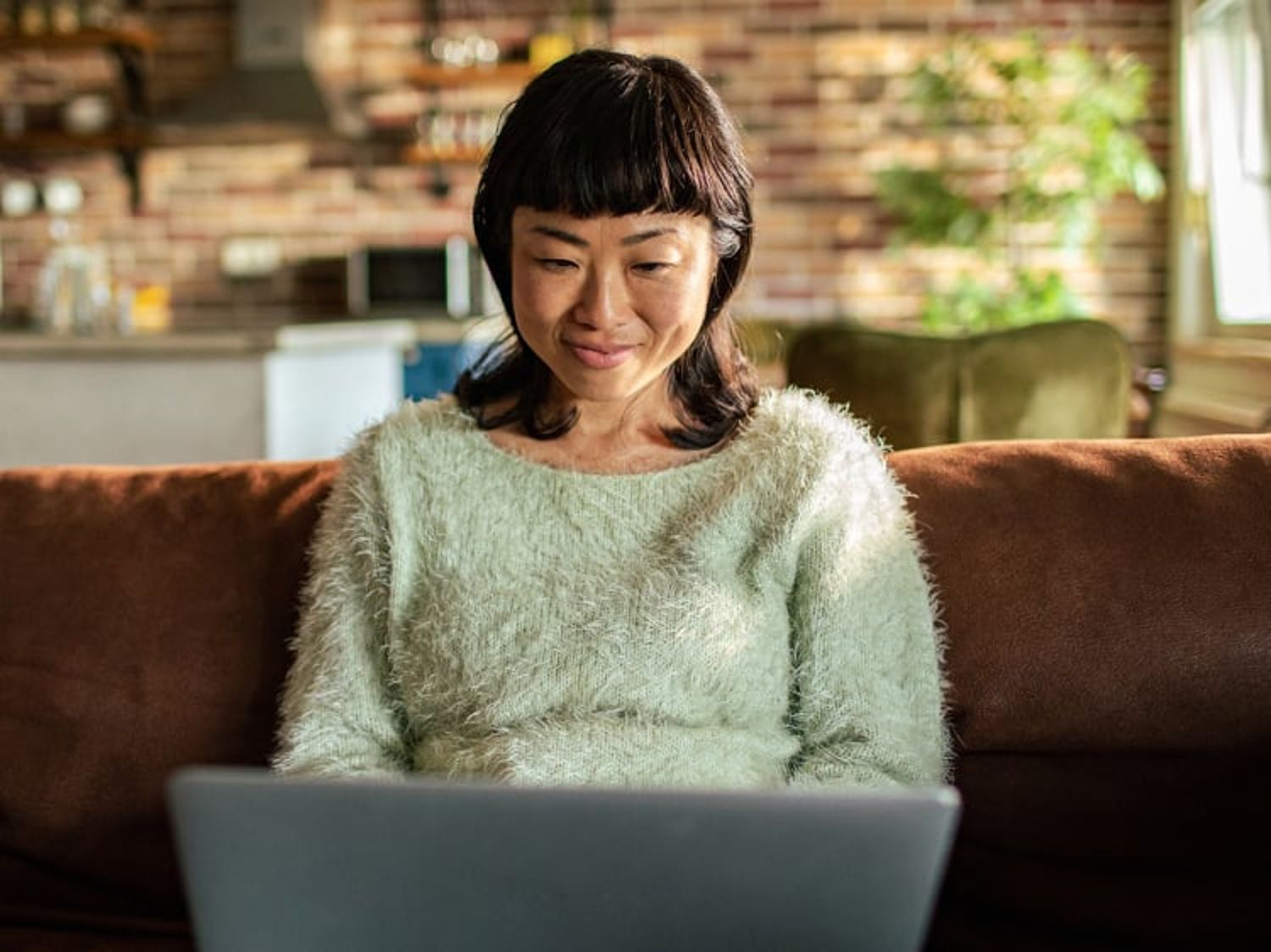 Woman smiling and looking at a laptop