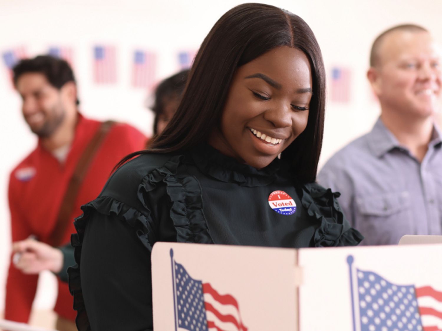 Woman smiling and voting at a polling booth