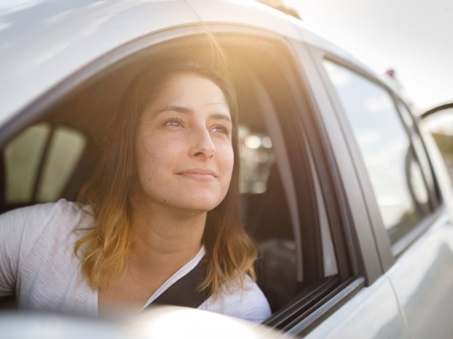 Woman smiling and looking out of the window of her Volvo SUV