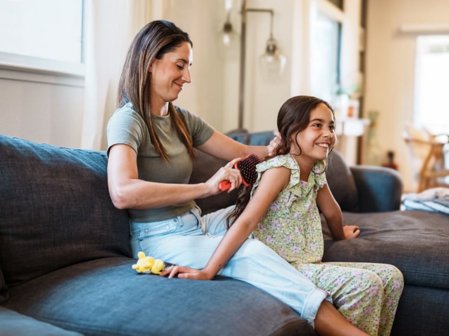 Woman braiding child's hair