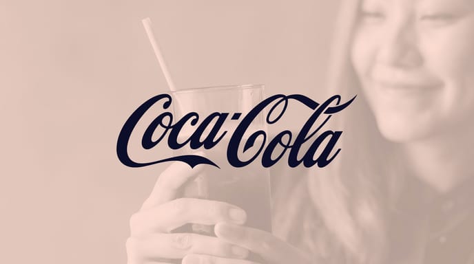 A woman smiles while holding a glass of cola with a paper straw, overlaid with the Coca-Cola logo.