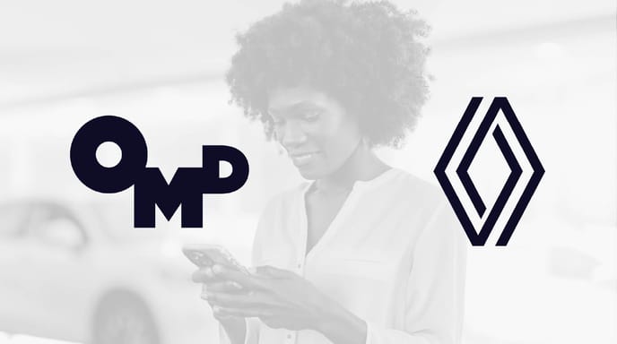 A woman smiles while looking at her phone, with the OMD and Renault logos prominently displayed on either side of her.