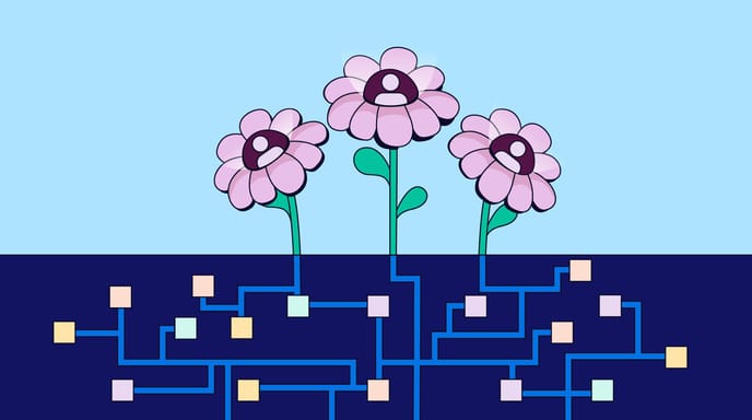 Image shows a trio of flowers above soil containing interconnected digital circuits and colored squares, against a light blue background.