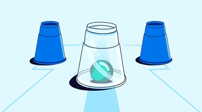 Three cups are arranged in a row with a teal ball visible under the transparent center cup.