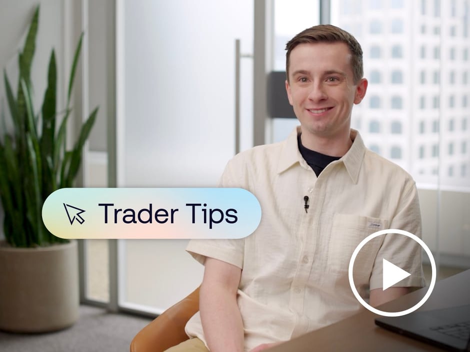 Man sitting at a desk with a graphic of text saying "Trader Tips" and a play button placed over him