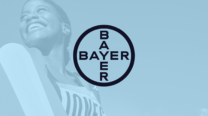 An olympian smiling and wrapped in the American flag with a blue overlay and the Bayer logo in the center
