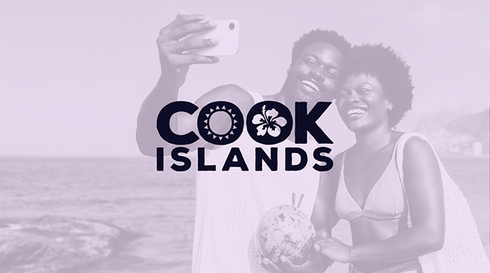 A promotional image with a soft-toned filter, featuring the Cook Islands logo over a background of a happy couple taking a selfie on the beach while holding a fresh coconut with straws.