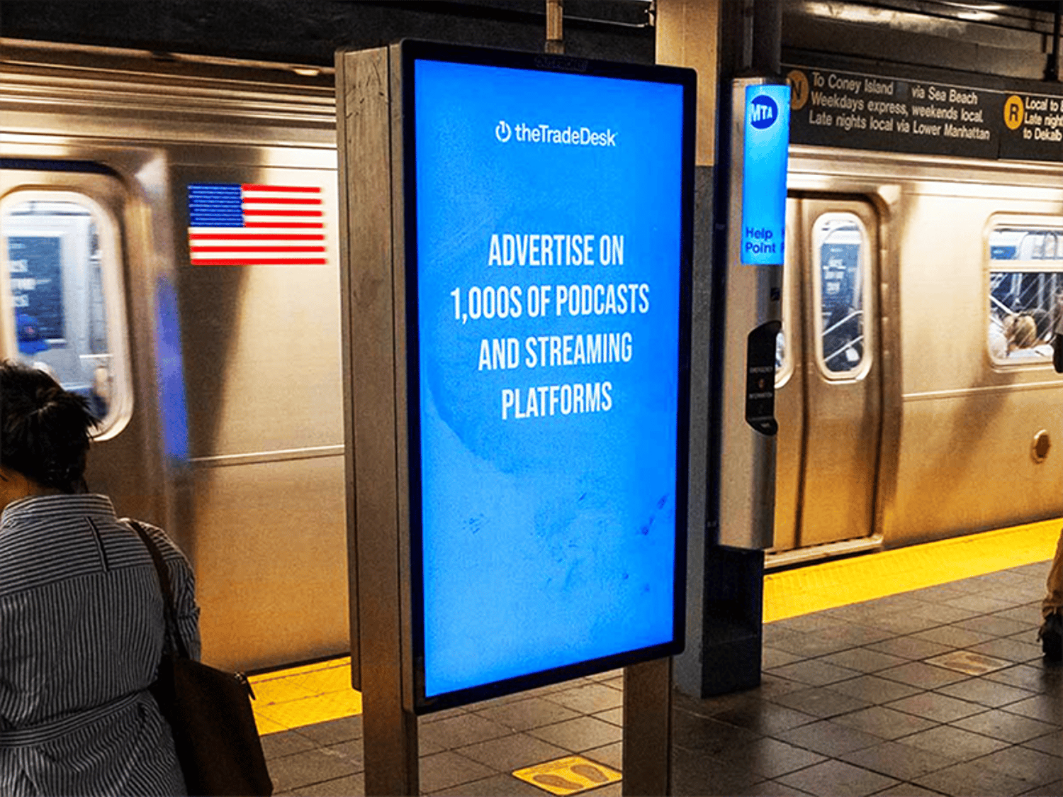 A digital ad in a New York City subway station promotes The Trade Desk's podcast and streaming platform advertising services.
