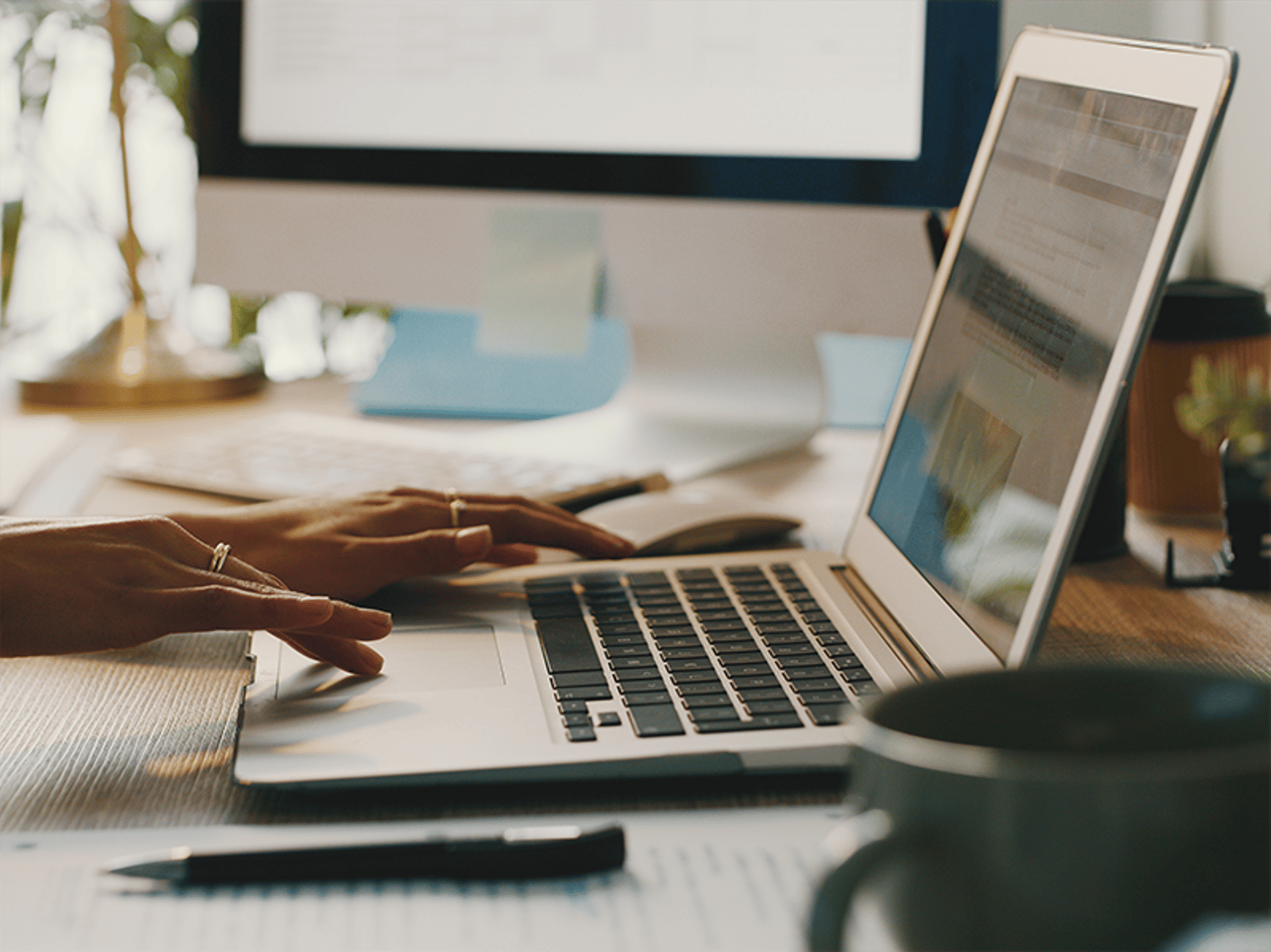 Hands typing on a laptop computer