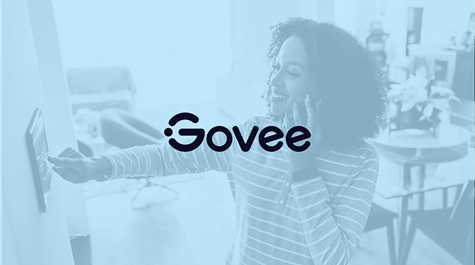 Woman speaking on a phone while clicking a wall unit with a blue wash over and the Govee logo in the center