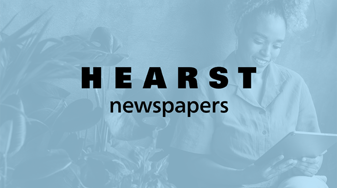 Woman in a yellow shirt sitting and looking at her tablet with a blue wash over and the Hearst Newspapers logo in the center.
