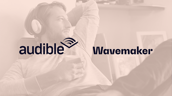 A man relaxing on a chair, wearing headphones and holding a cup, with a content expression, with an orange overlay and the Audible and Wavemaker logos in the center.